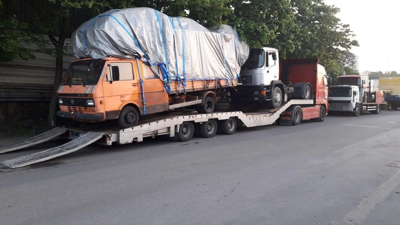 Transporter loaded with a van and a truck for export